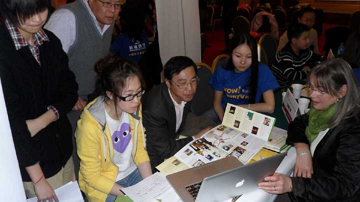 01China.jpg - Andrea Beall, right,  presents knowledge on Consciousness-Based Education at a school fair in China. Up to 100 other schools and universities from around the world were represented at school fairs around the nation.