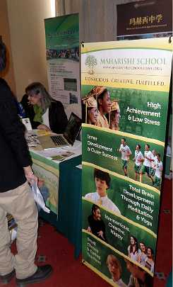 02China.jpg - Representatives answer questions from prospective students and their families at the Maharishi School of the Age of Enlightenment (MSAE) display at a school fair.