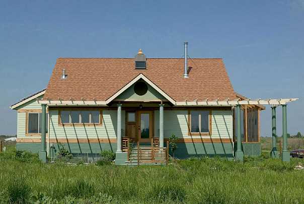 85.jpg - The first house built in Abundance EcoVillage. During the summer deciduous vines grow up the trellis on the eastern side allowing the nourishing influence of the early morning sun to enter, but shading eastern windows as the sun rises to keep the house cool. In the winter the vines die back and the morning sun warms the house.