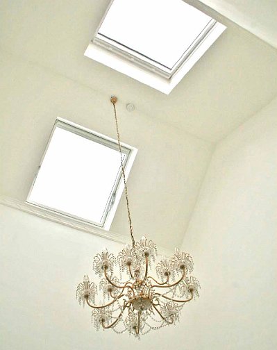 Slide21.jpg - Skylights allow natural light to beam in from the top floor rooms by day. A chandelier lights the area by night.