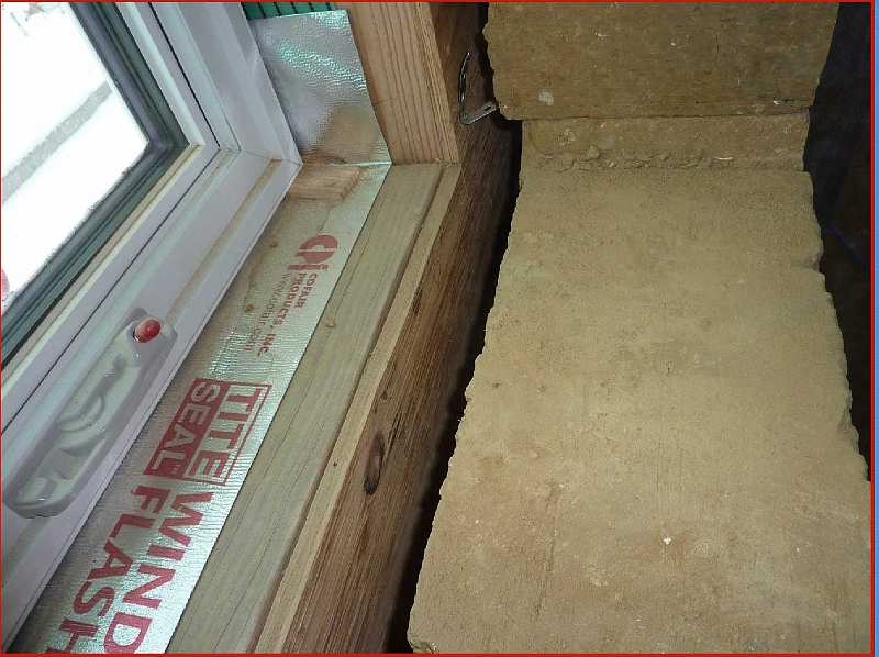 Slide29.jpg - A section of wall near the window shows 8 inches of cellulose insulation separated by two inches of air, and then 18 inches of wall from the compact earth blocks.